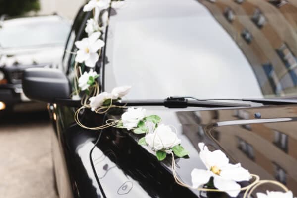 Photo of an SUV with purple silk bows on the doorhandles for a wedding.